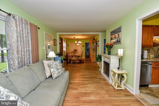 24 Haddon Rd, Somers Point, NJ 08244 - living room featuring a chandelier, light wood-style flooring, and a fireplace