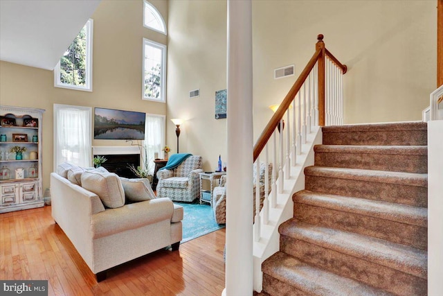 14 Wyomissing Ct, Wyomissing, PA 19610 - living room with a towering ceiling, stairway, light wood-style floors, and a fireplace