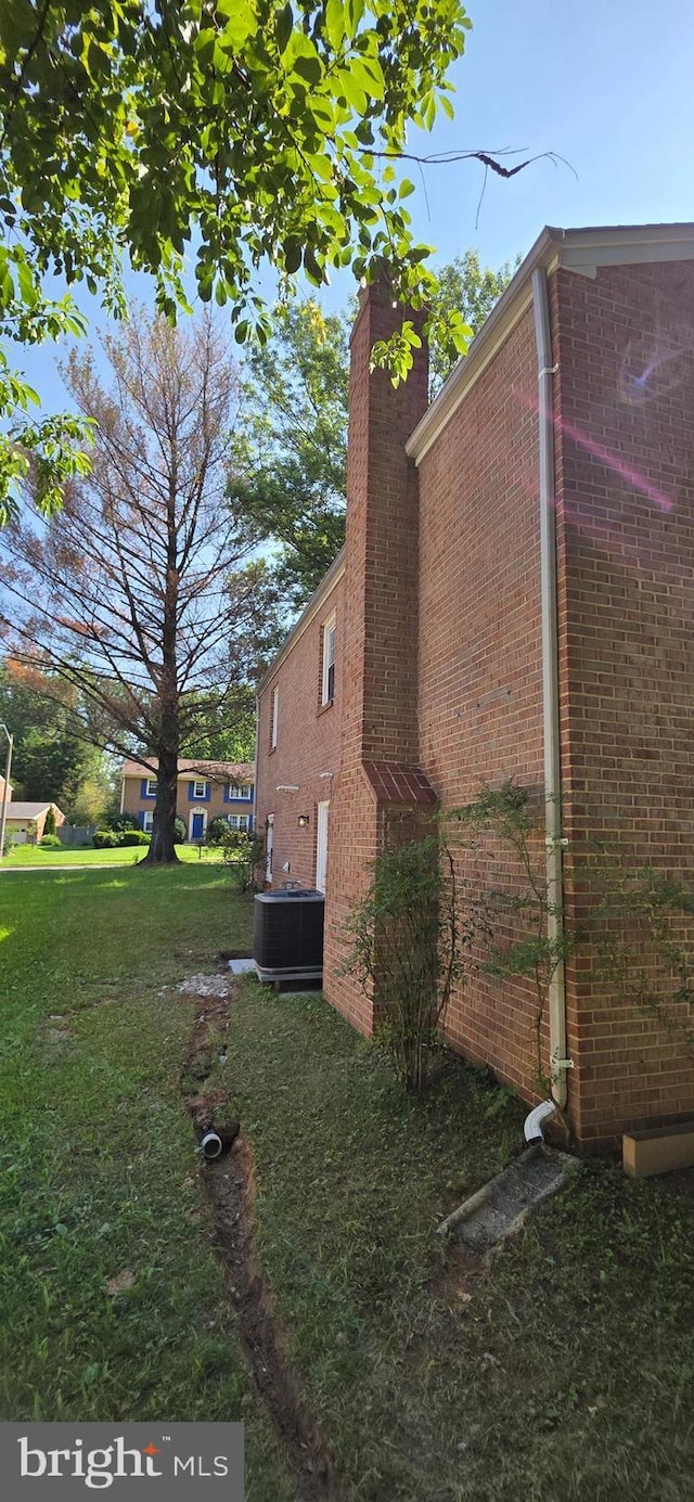 3478 Pence Ct, Annandale, VA 22003 - view of side of home featuring brick siding, a chimney, and a lawn