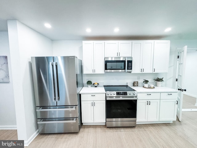 7 N Stuyvesant Dr, Wilmington, DE 19809 - kitchen with appliances with stainless steel finishes, light wood finished floors, white cabinets, light countertops, and recessed lighting