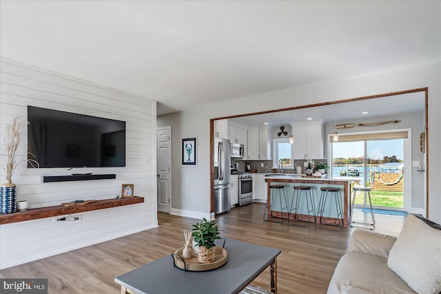 6934 River Drive Rd, Sparrows Point, MD 21219 - living area with light wood finished floors, wood walls, and recessed lighting