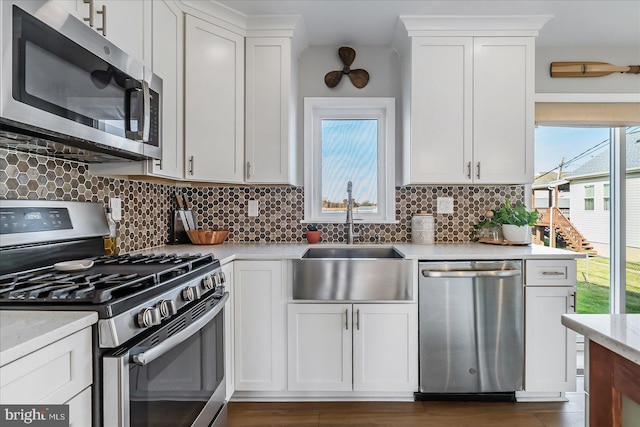 6934 River Drive Rd, Sparrows Point, MD 21219 - kitchen with stainless steel appliances, tasteful backsplash, white cabinets, and dark wood-type flooring