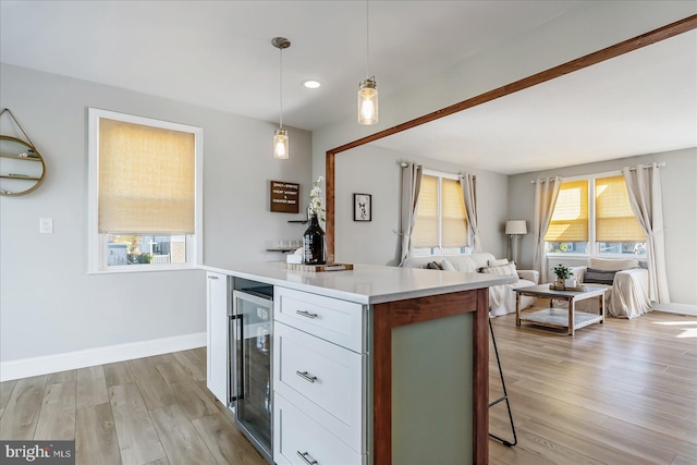 6934 River Drive Rd, Sparrows Point, MD 21219 - kitchen featuring wine cooler, open floor plan, a breakfast bar area, light wood-type flooring, and light countertops