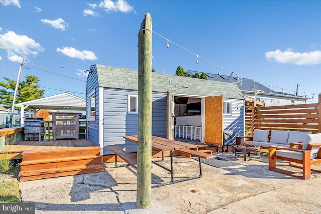 6934 River Drive Rd, Sparrows Point, MD 21219 - rear view of property with a shingled roof, a patio, an outdoor hangout area, an outdoor structure, and a wooden deck
