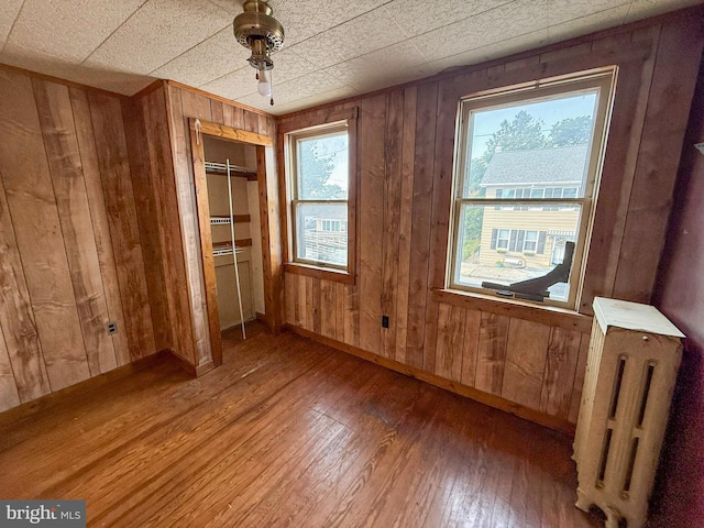 507 Market St, New Cumberland, PA 17070 - unfurnished bedroom featuring radiator, wood-type flooring, and wood walls