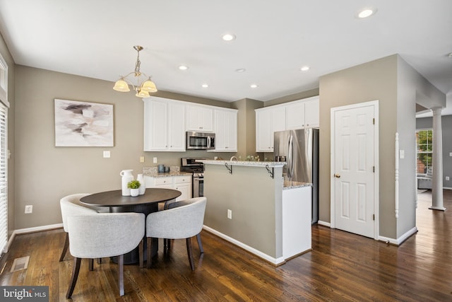 8562 Wyngate Manor Ct, Alexandria, VA 22309 - kitchen with appliances with stainless steel finishes, dark wood-style flooring, a center island with sink, white cabinets, and a chandelier