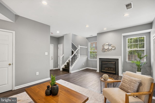 8562 Wyngate Manor Ct, Alexandria, VA 22309 - living room featuring dark wood-style flooring, stairs, a glass covered fireplace, plenty of natural light, and recessed lighting