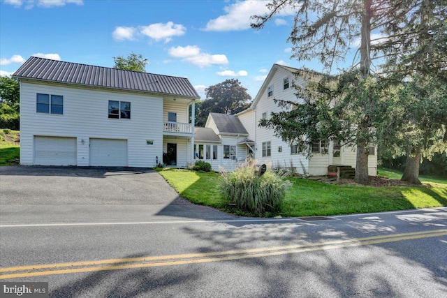 270 Gouglersville Rd, Reading, PA 19608 - view of front facade with an attached garage, driveway, a front lawn, a balcony, and a metal roof