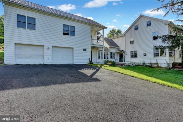 270 Gouglersville Rd, Reading, PA 19608 - view of front facade featuring a balcony, an attached garage, asphalt driveway, a metal roof, and a front yard