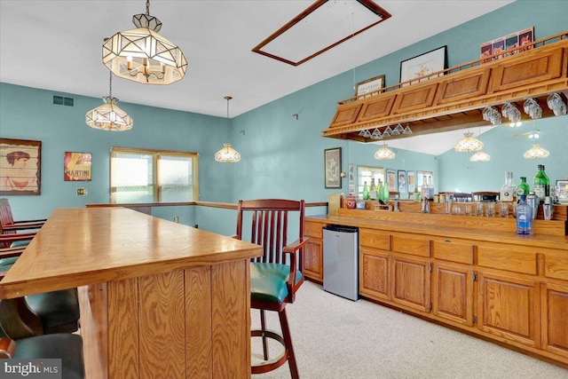 270 Gouglersville Rd, Reading, PA 19608 - kitchen with fridge, light carpet, a kitchen bar, pendant lighting, and brown cabinetry