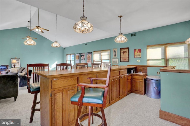 270 Gouglersville Rd, Reading, PA 19608 - kitchen with light carpet, a ceiling fan, a kitchen breakfast bar, lofted ceiling, and brown cabinetry