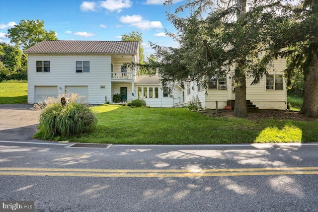 270 Gouglersville Rd, Reading, PA 19608 - view of front of house with an attached garage, concrete driveway, a front lawn, a metal roof, and a balcony