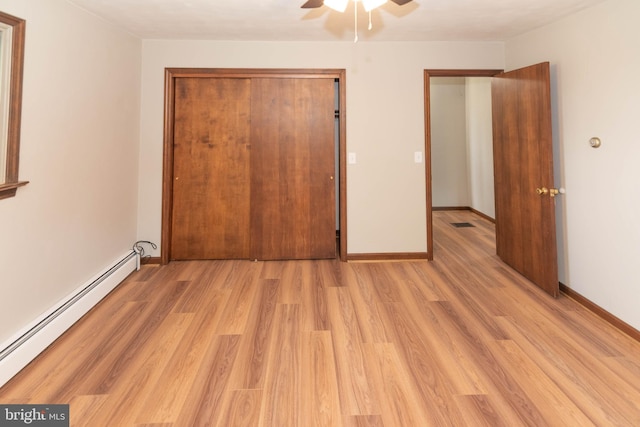 640 Bollinger Rd, Littlestown, PA 17340 - unfurnished bedroom with a baseboard radiator, light wood finished floors, a ceiling fan, and a closet