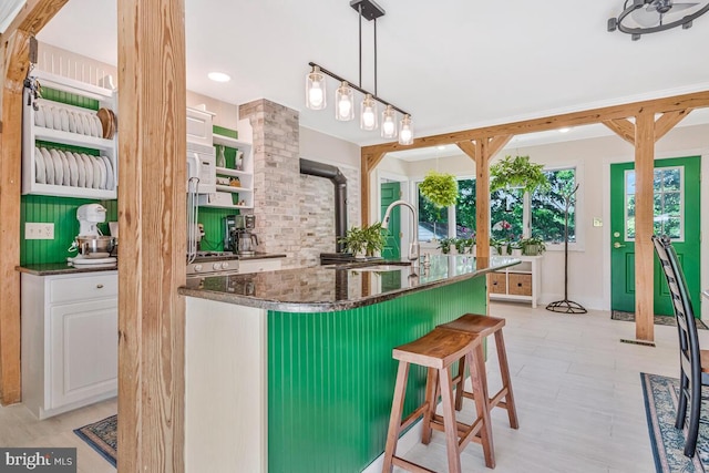 2090 Clearview Dr, Owings, MD 20736 - kitchen featuring a kitchen bar, a center island with sink, white cabinetry, pendant lighting, and dark stone countertops