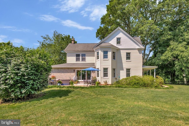 2090 Clearview Dr, Owings, MD 20736 - back of house featuring a chimney, a lawn, and a patio