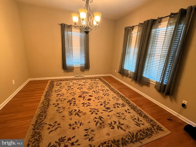 89 Wheeler Cir, Smyrna, DE 19977 - spare room with a chandelier and dark wood-type flooring