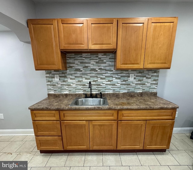 5349 Lindbergh Blvd, Philadelphia, PA 19143 - kitchen with dark countertops, decorative backsplash, light tile patterned floors, and brown cabinets