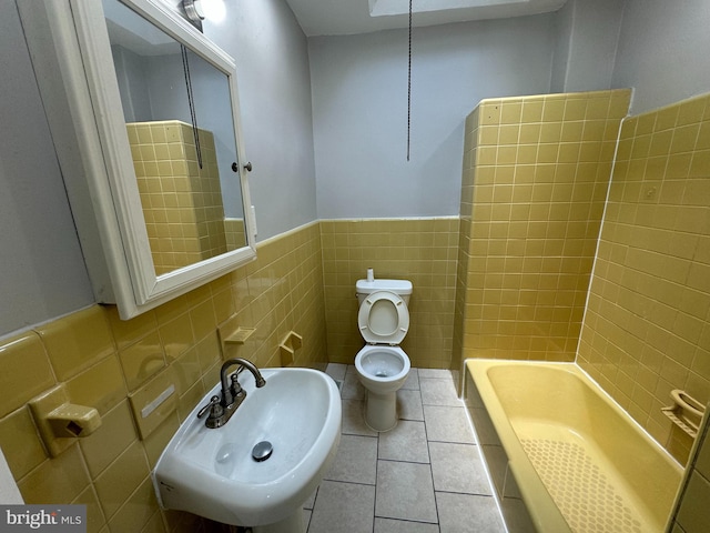 5349 Lindbergh Blvd, Philadelphia, PA 19143 - bathroom featuring tile walls, a tub to relax in, a wainscoted wall, and tile patterned floors