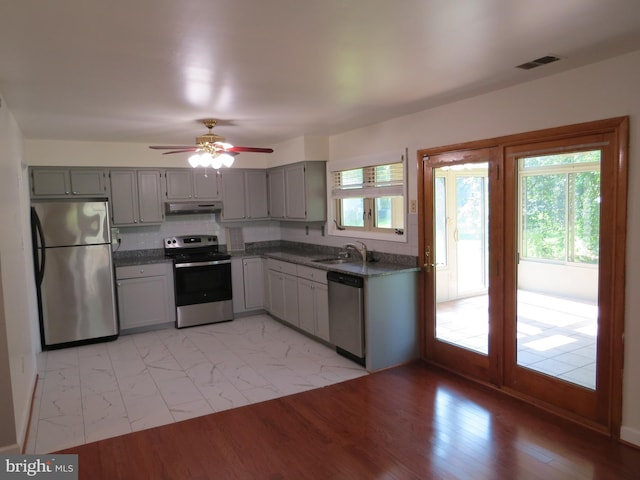 1208 Pickering Cir, Upper Marlboro, MD 20774 - kitchen featuring appliances with stainless steel finishes, under cabinet range hood, dark countertops, gray cabinets, and a ceiling fan