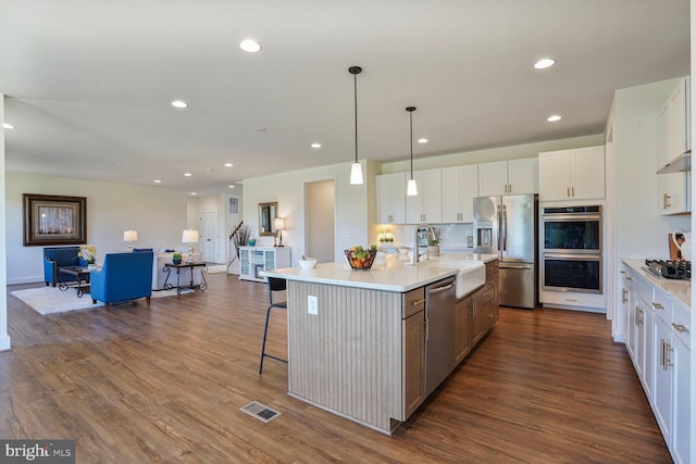 11100 Slate Landing Ln, Nokesville, VA 20181 - kitchen with appliances with stainless steel finishes, dark wood-style flooring, white cabinetry, light countertops, and recessed lighting