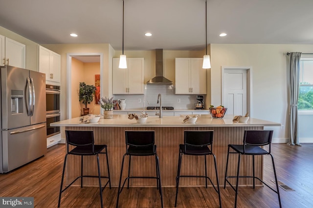 11100 Slate Landing Ln, Nokesville, VA 20181 - kitchen with appliances with stainless steel finishes, wall chimney exhaust hood, white cabinets, dark wood-style flooring, and recessed lighting