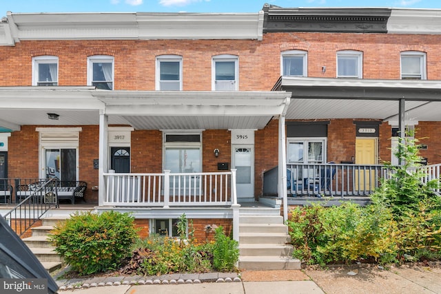 3915 Falls Rd, Baltimore, MD 21211 - townhome / multi-family property featuring a porch and brick siding