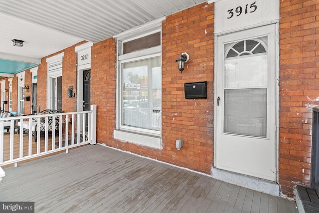 3915 Falls Rd, Baltimore, MD 21211 - doorway to property featuring brick siding and a porch