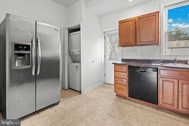 3915 Falls Rd, Baltimore, MD 21211 - kitchen featuring black dishwasher, stainless steel fridge, estacked washer and dryer, dark countertops, and healthy amount of natural light