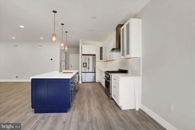 51FRANKLINDR Franklin Dr, Mechanicsburg, PA 17055 - kitchen featuring stainless steel appliances, wall chimney range hood, blue cabinets, light wood-style flooring, and white cabinetry
