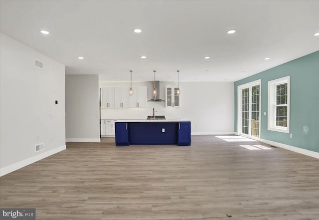 51FRANKLINDR Franklin Dr, Mechanicsburg, PA 17055 - kitchen featuring wall chimney range hood, open floor plan, white cabinetry, light wood-style flooring, and blue cabinets