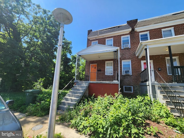 5228 Denmore Ave, Baltimore, MD 21215 - view of property featuring brick siding, stairs, and mansard roof
