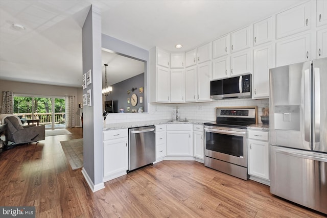 213 Buchanan Ct, Downingtown, PA 19335 - kitchen featuring appliances with stainless steel finishes, white cabinetry, backsplash, light wood-style flooring, and open floor plan