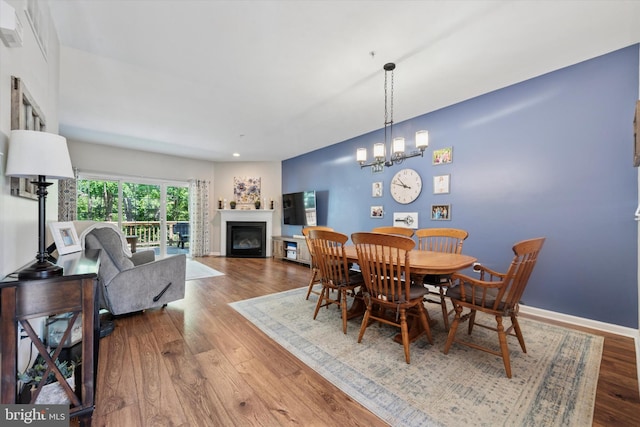 213 Buchanan Ct, Downingtown, PA 19335 - dining area featuring a glass covered fireplace, wood finished floors, recessed lighting, and a chandelier