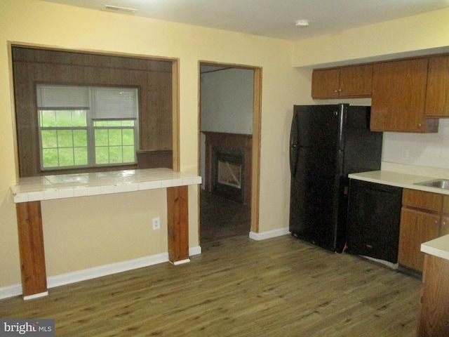 2 Queen Anne Dr, Boyertown, PA 19512 - kitchen featuring black appliances, brown cabinets, wood finished floors, and a fireplace