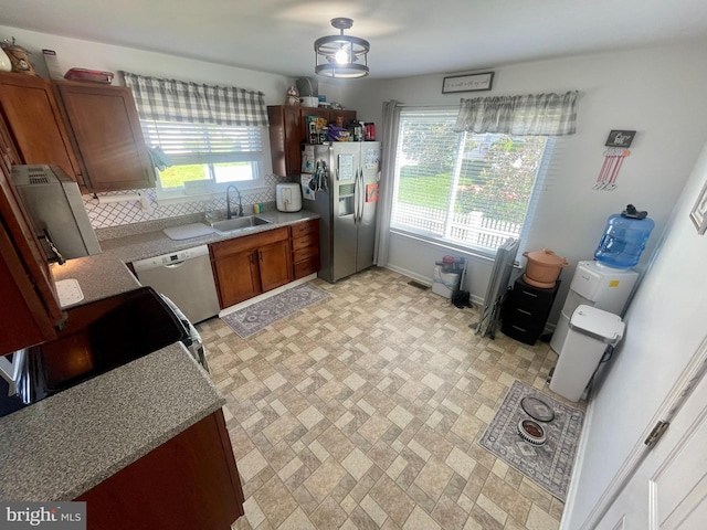 8 Aidone Ln, Smyrna, DE 19977 - kitchen featuring stainless steel fridge with ice dispenser, dishwashing machine, brown cabinets, and brick patterned flooring