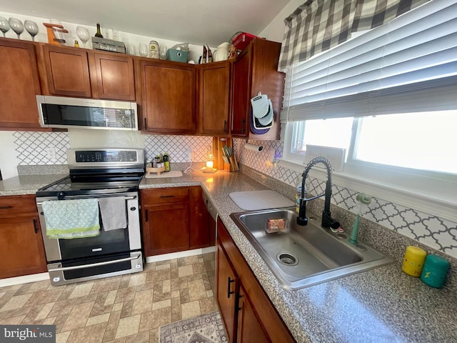8 Aidone Ln, Smyrna, DE 19977 - kitchen featuring stainless steel appliances, tasteful backsplash, brown cabinetry, and light countertops