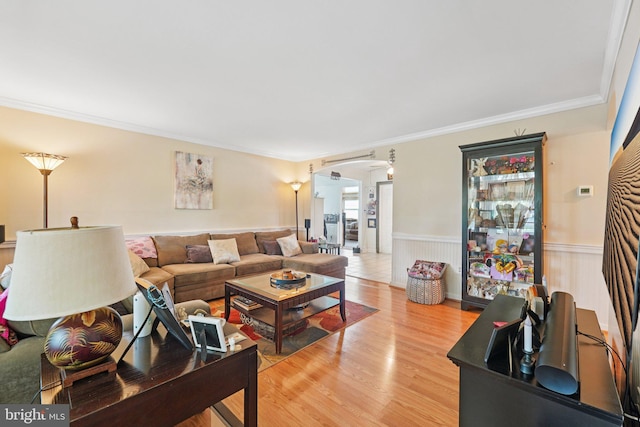 28 Indian Red Rd, Levittown, PA 19057 - living room with arched walkways, wainscoting, ornamental molding, and light wood-style floors