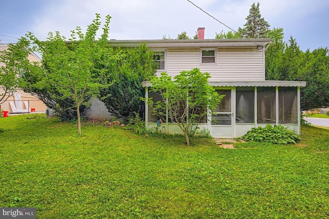 231 Candytuft Rd, Reisterstown, MD 21136 - rear view of house with a sunroom, a chimney, and a lawn