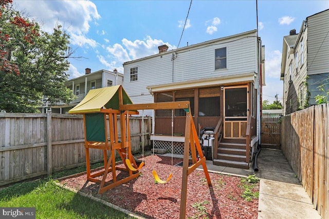 432 Mcdowell Ave, Hagerstown, MD 21740 - rear view of house with a playground, a sunroom, a chimney, a fenced backyard, and entry steps