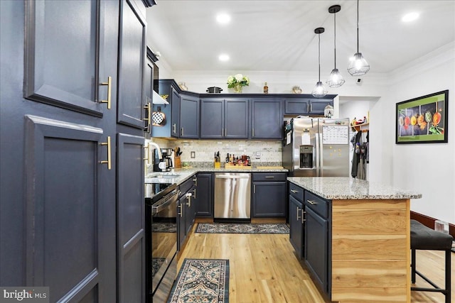 432 Mcdowell Ave, Hagerstown, MD 21740 - kitchen with appliances with stainless steel finishes, light wood finished floors, a kitchen bar, backsplash, and a center island