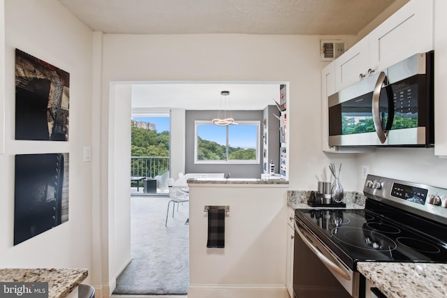 2059 Huntington Ave Unit 1406, Alexandria, VA 22303 - kitchen featuring appliances with stainless steel finishes, white cabinetry, light stone counters, carpet flooring, and decorative light fixtures