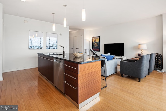 2101 Market St Unit 2801, Philadelphia, PA 19103 - kitchen featuring modern cabinets, stainless steel dishwasher, light wood-style floors, a kitchen island with sink, and a kitchen bar