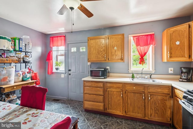 3170 Merriel Ave, Camden, NJ 08105 - kitchen with a ceiling fan, light countertops, stainless steel gas range oven, dark floors, and brown cabinets