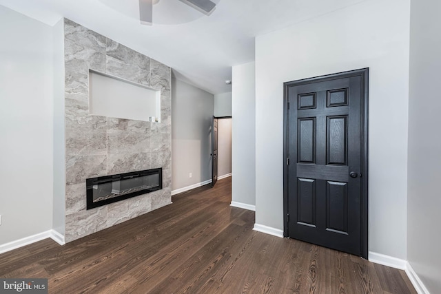 1715 E Oliver St, Baltimore, MD 21213 - unfurnished living room featuring a fireplace, a ceiling fan, and dark wood-type flooring