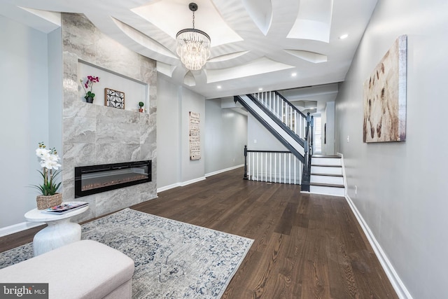 1715 E Oliver St, Baltimore, MD 21213 - living area with wood finished floors, a tiled fireplace, a chandelier, stairway, and recessed lighting