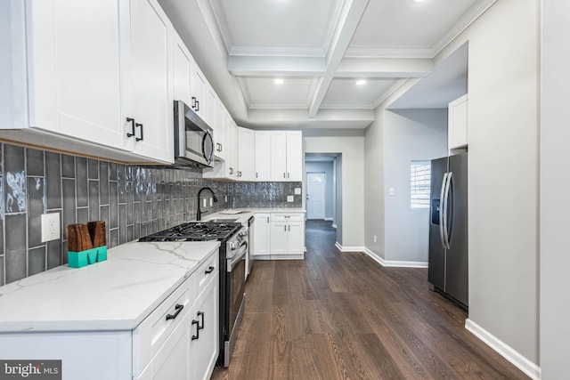 1715 E Oliver St, Baltimore, MD 21213 - kitchen with appliances with stainless steel finishes, dark wood-style flooring, beamed ceiling, backsplash, and white cabinets
