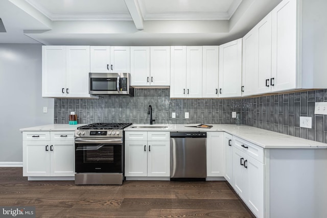 1715 E Oliver St, Baltimore, MD 21213 - kitchen featuring appliances with stainless steel finishes, dark wood-style floors, light stone countertops, ornamental molding, and white cabinetry