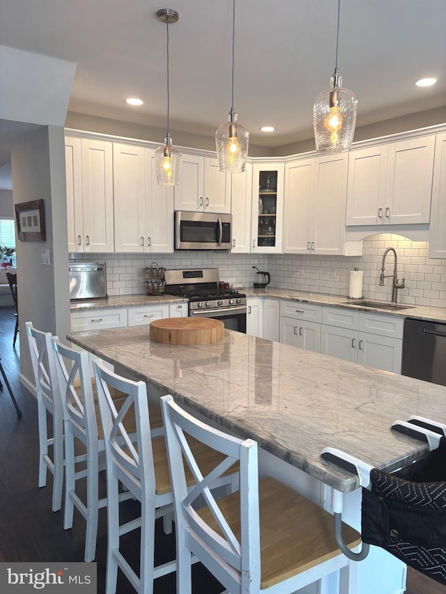 420 Fairview Way, New Hope, PA 18938 - kitchen with stainless steel appliances, a kitchen breakfast bar, white cabinetry, tasteful backsplash, and hanging light fixtures