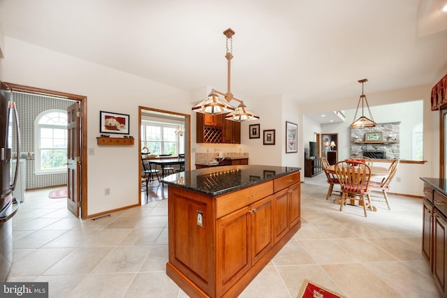 69 Fairfield Ln, Chester Springs, PA 19425 - kitchen with a stone fireplace, dark stone counters, a kitchen island, light tile patterned floors, and recessed lighting