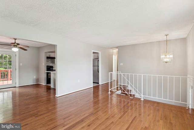 9405 Loughran Rd, Fort Washington, MD 20744 - spare room featuring wood finished floors, a chandelier, a ceiling fan, and a textured ceiling